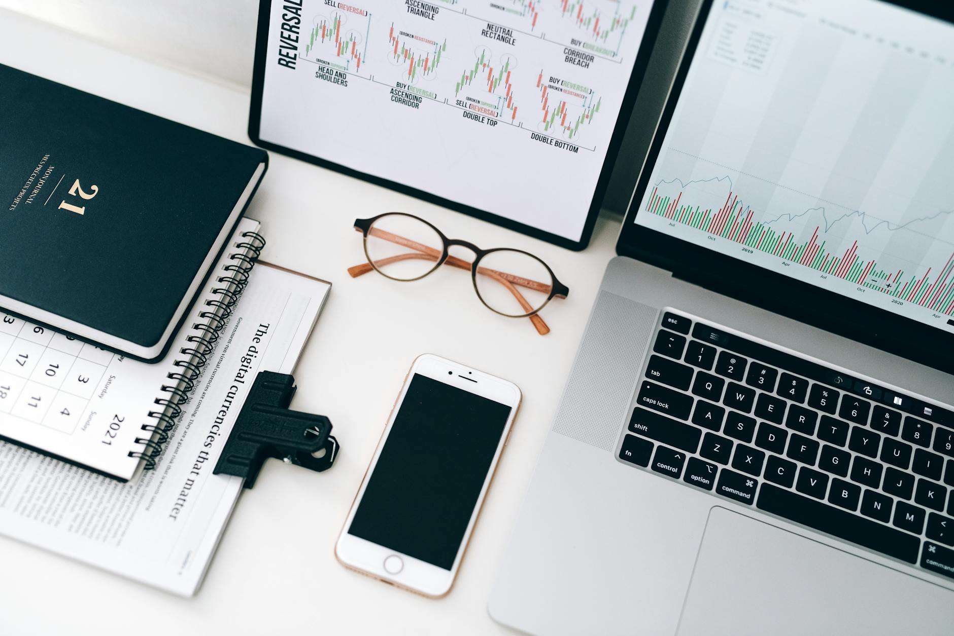 laptop beside eyeglasses and smartphone