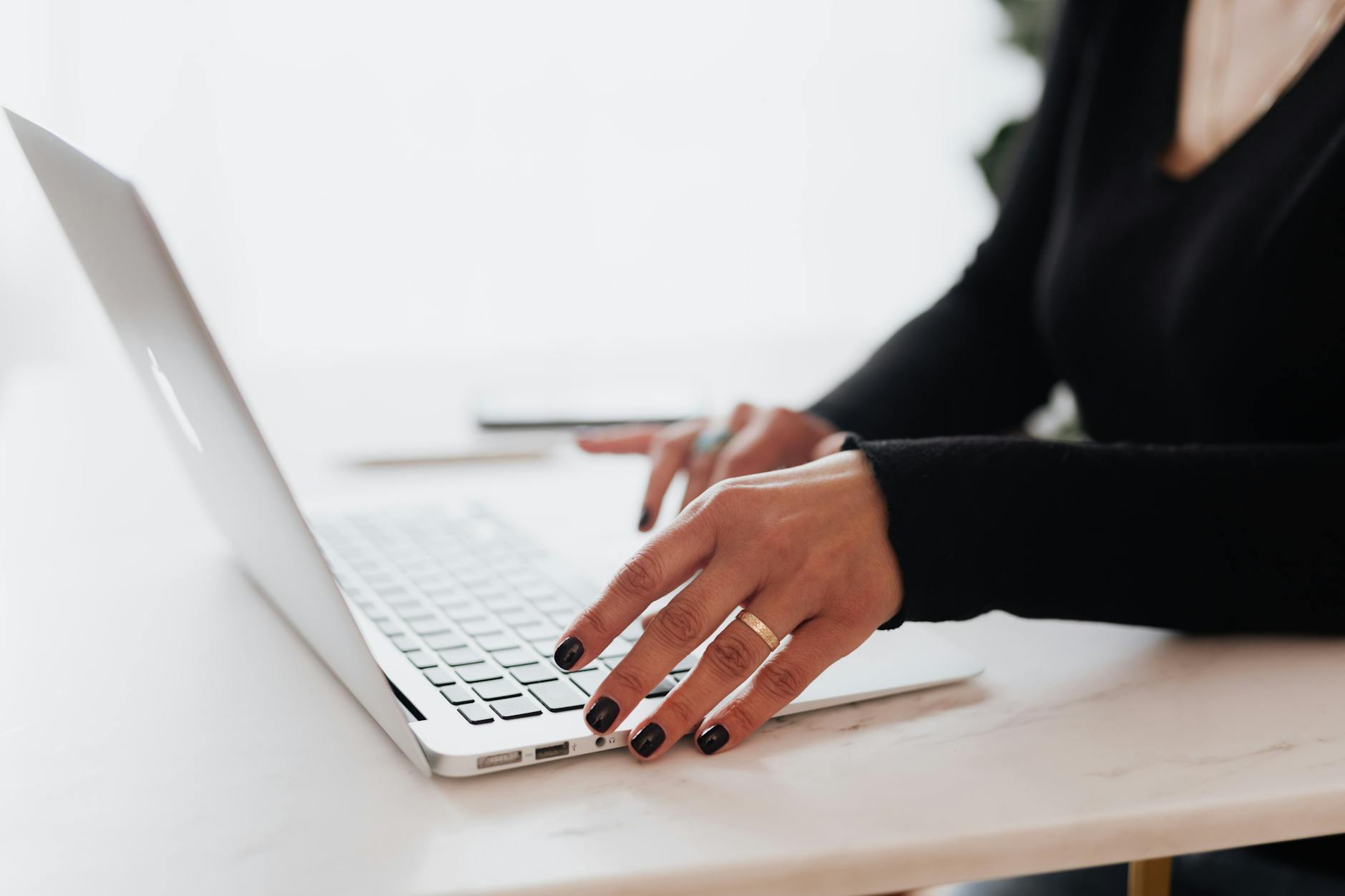 crop woman using laptop in modern workplace