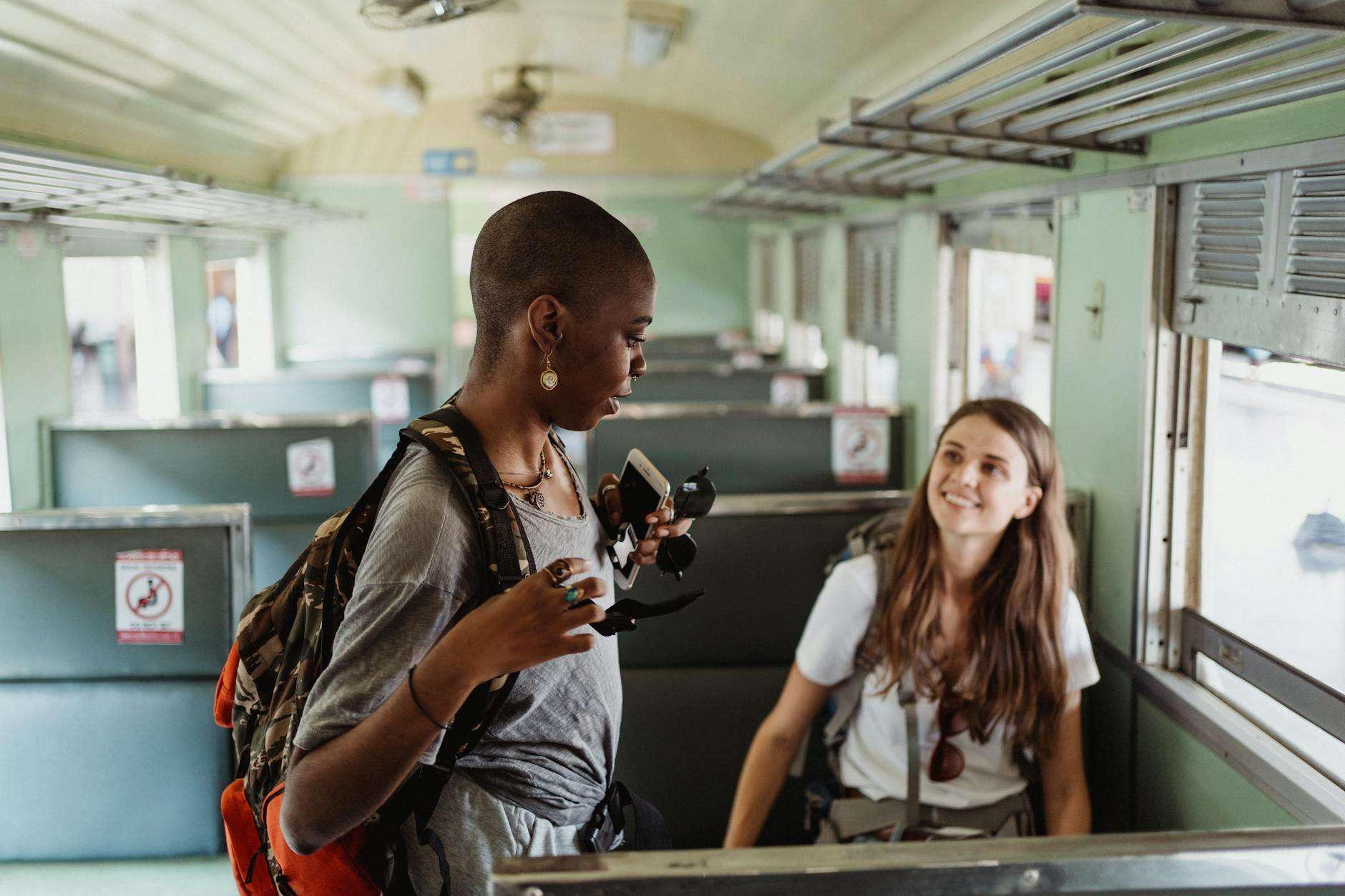 women sitting in a train and smiling