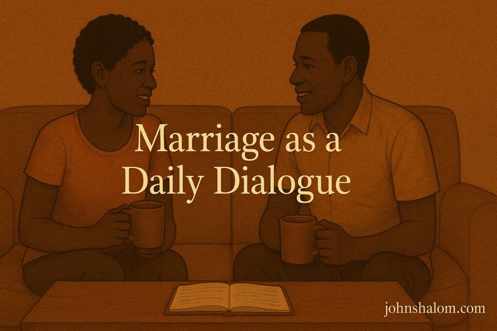 A couple sits together on a couch with two mugs, talking gently while a notebook of shared plans rests on the table.
